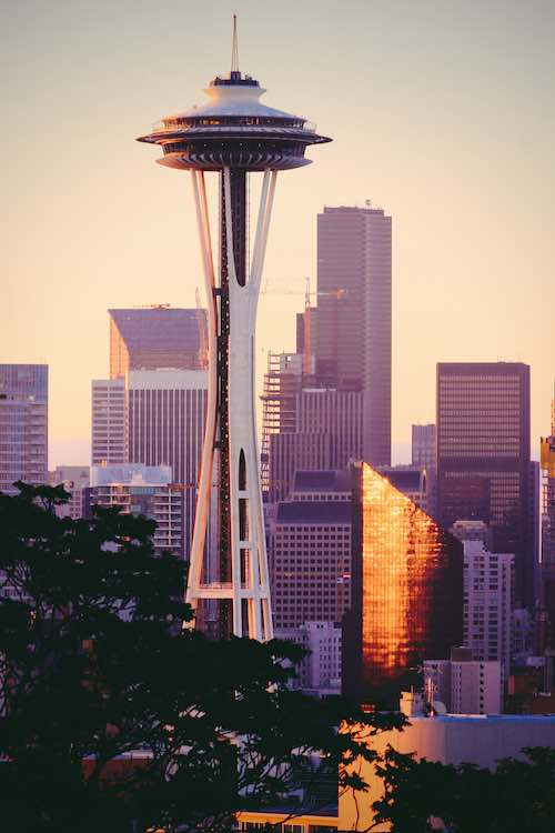 Photo of the space needle against a purple and orange sky.